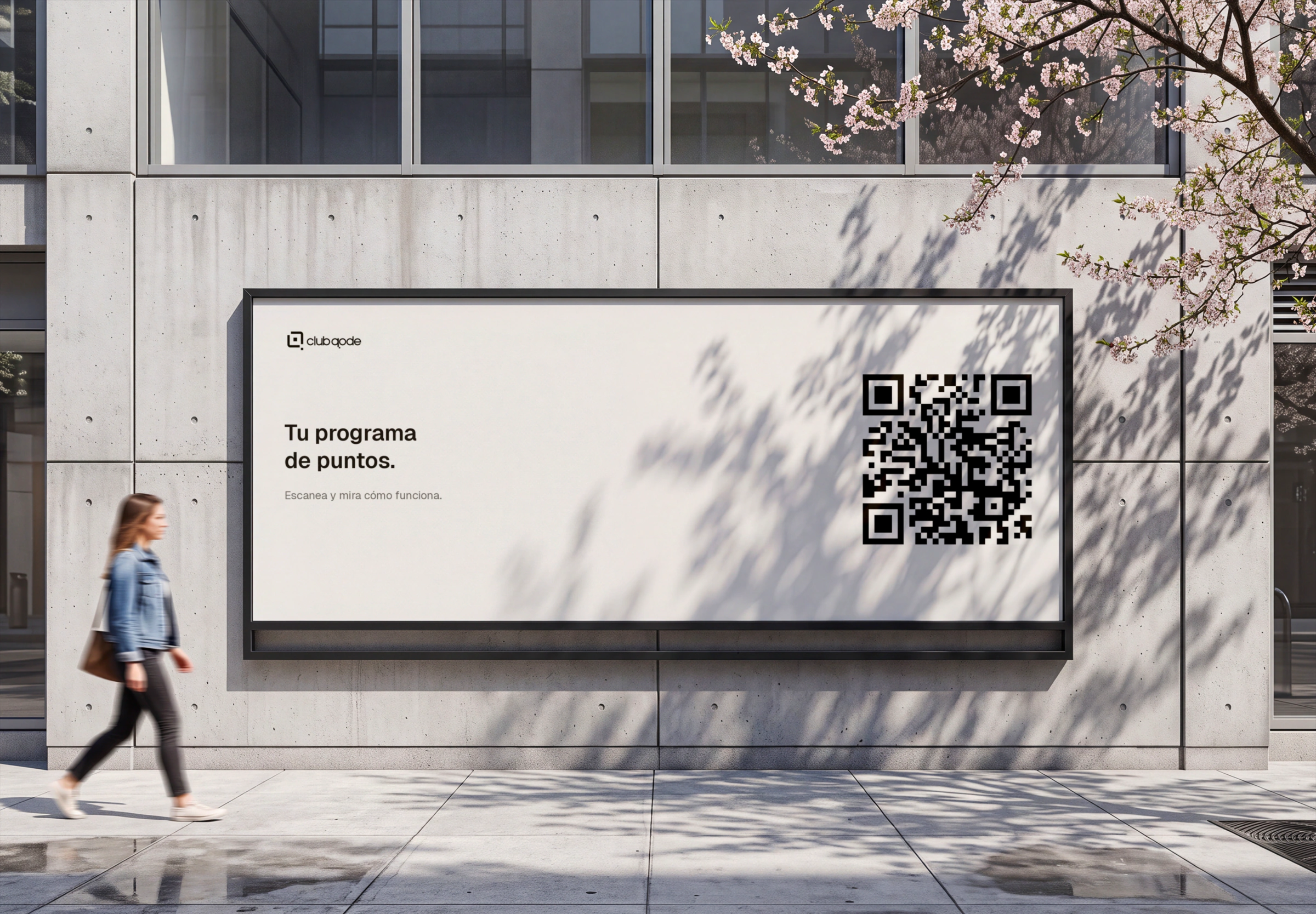 Un cartel con el QR del programa en la fachada de un edificio, con una persona pasando por delante.